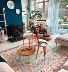 a living room filled with furniture and a fire place in front of a large window