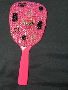 a pink paddle with black bows and hearts on it