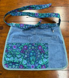 a purse made from an old pair of jeans with a flowered design on it