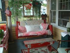 the porch is decorated with red and white furniture