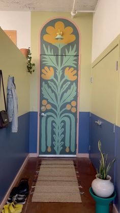 a hallway with blue and yellow painted walls, an entryway to the room has a potted plant next to it