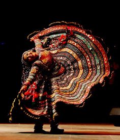 a woman is dancing with an elaborate costume