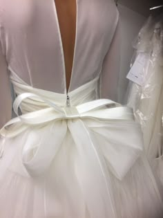 the back of a white dress with a bow on it