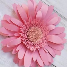 a pink flower sitting on top of a wooden table