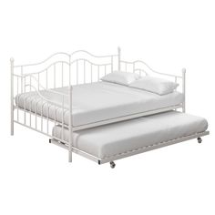 a white metal daybed with two pillows on it and a pull out trundle