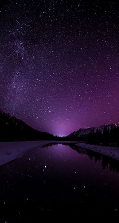 the night sky is reflected in a lake