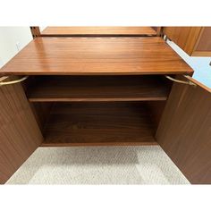 a wooden desk with two drawers and one shelf on the bottom, next to a carpeted floor