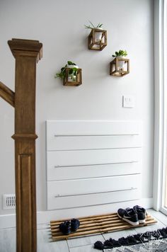 a pair of black shoes sitting on top of a wooden floor next to a radiator