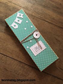 a green box with white polka dots on it and a tag hanging from the top