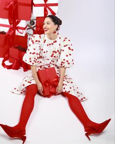 a woman sitting on the floor holding a red present