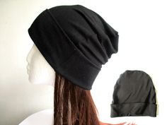 a woman with long hair wearing a black hat on top of a white mannequin head