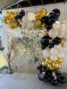 black, gold and white balloons hanging from a wall