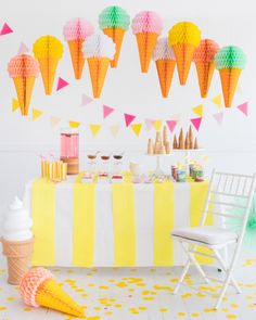 an ice cream cone is on the table next to some paper cones and other decorations