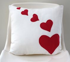 a white pillow with red hearts on it