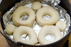 doughnuts are sitting on tin foil in a pot