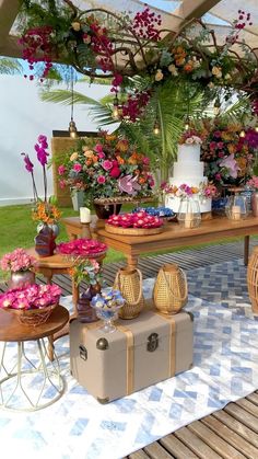 a table topped with lots of flowers next to two suitcases on top of a checkered floor