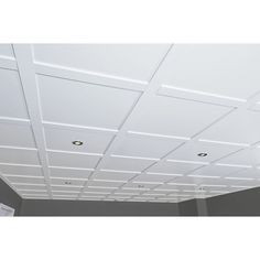 an empty room with white ceiling tiles on the ceiling and light fixtures in the ceiling