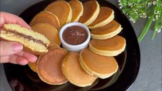 a plate that has pancakes on it with chocolate sauce in the middle and flowers behind