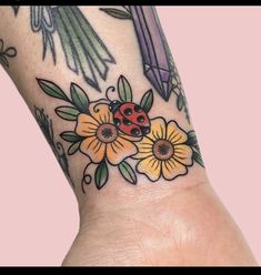 a ladybug tattoo on the wrist with flowers and birds around it's neck