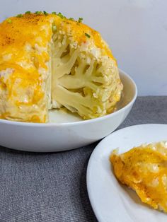 a plate with a piece of broccoli covered in cheese next to a bowl