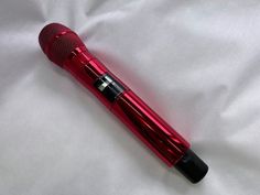 a red microphone sitting on top of a white sheet