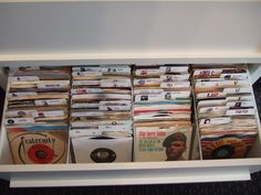 a shelf filled with lots of different types of records and cds on top of each other