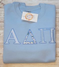 Show your ADPi pride in this themed sweatshirt! With the option to pick fabrics and colors, you can either keep the symbolic sorority theme and use the violets fabric or get creative and make it fully your own. It is a Gildan sweatshirt. Adpi Shirts, Alpha Omega Epsilon, Sorority Themes, Sorority Sweatshirts, Sorority Letters, Sorority Big Little, Pi Beta Phi, Sorority Tshirts, Trendy Fits