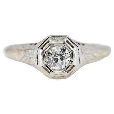 an antique diamond engagement ring with filigrees