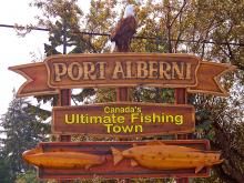 a sign for port alberni, canada's ultimate fishing town with an eagle on top