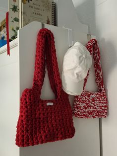 two purses hanging on the wall next to each other