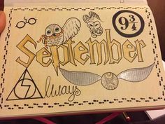 someone is holding up a notebook with harry potter symbols on it and the words, september always