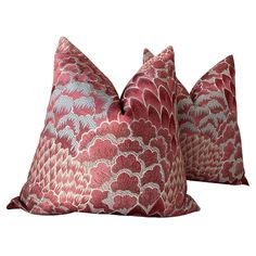 two red and white decorative pillows on a white background