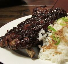 a white plate topped with meat and rice