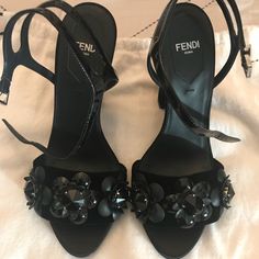 Black Leather And Velvet Flower Applique Sandal From Fendi. Open Toe, Branded Insole, Ankle Strap With Side Buckle High Heel Designer Embellished Patent Leather Sandals, Floral Embellished Open Toe Heels For Evening, Elegant Embellished Sandals In Patent Leather, Designer Black Embellished Sandals, Velvet Flower, Closet Tour, Classy Shoes, Velvet Flowers, Fendi Shoes