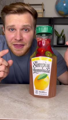 a man sitting at a table with a jar of fruit and sauce in front of him