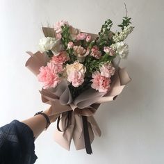 someone holding a bouquet of pink and white flowers