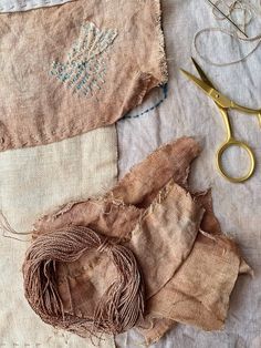 several pieces of cloth and scissors on a table with some thread in it's middle