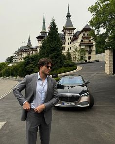 a man in a suit standing next to a car