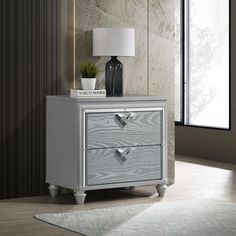 a grey nightstand with two drawers and a lamp