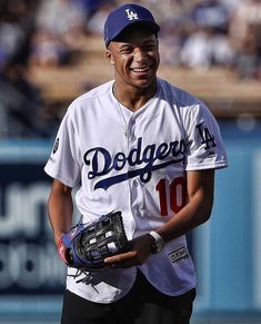 a baseball player holding a catchers mitt and smiling