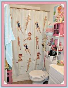 a bathroom with a shower curtain decorated in barbies on it and pink accessories around the bathtub