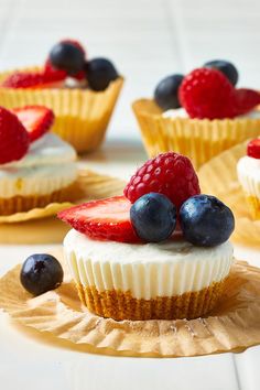 small cupcakes with berries and blueberries on top are ready to be eaten