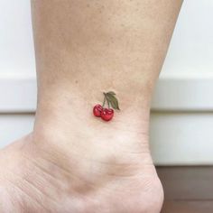 a small cherry tattoo on the ankle