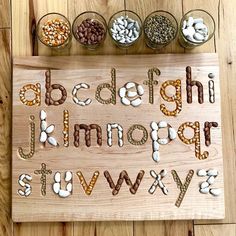 a wooden board with letters and numbers made out of nuts, beans, and other things