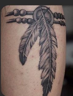 a black and white tattoo with a feather on it