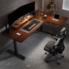 a computer desk with a monitor, keyboard and mouse on it in an office setting