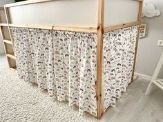 a wooden bed frame with curtains on it