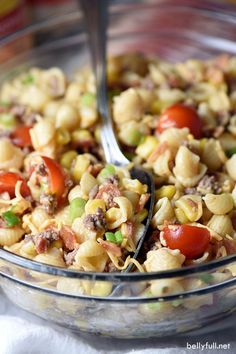 a glass bowl filled with pasta and vegetables