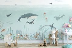 a child's room decorated in blue and green with an underwater scene on the wall