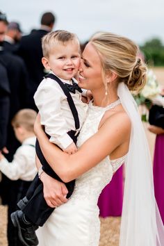 a woman in a wedding dress holding a young boy